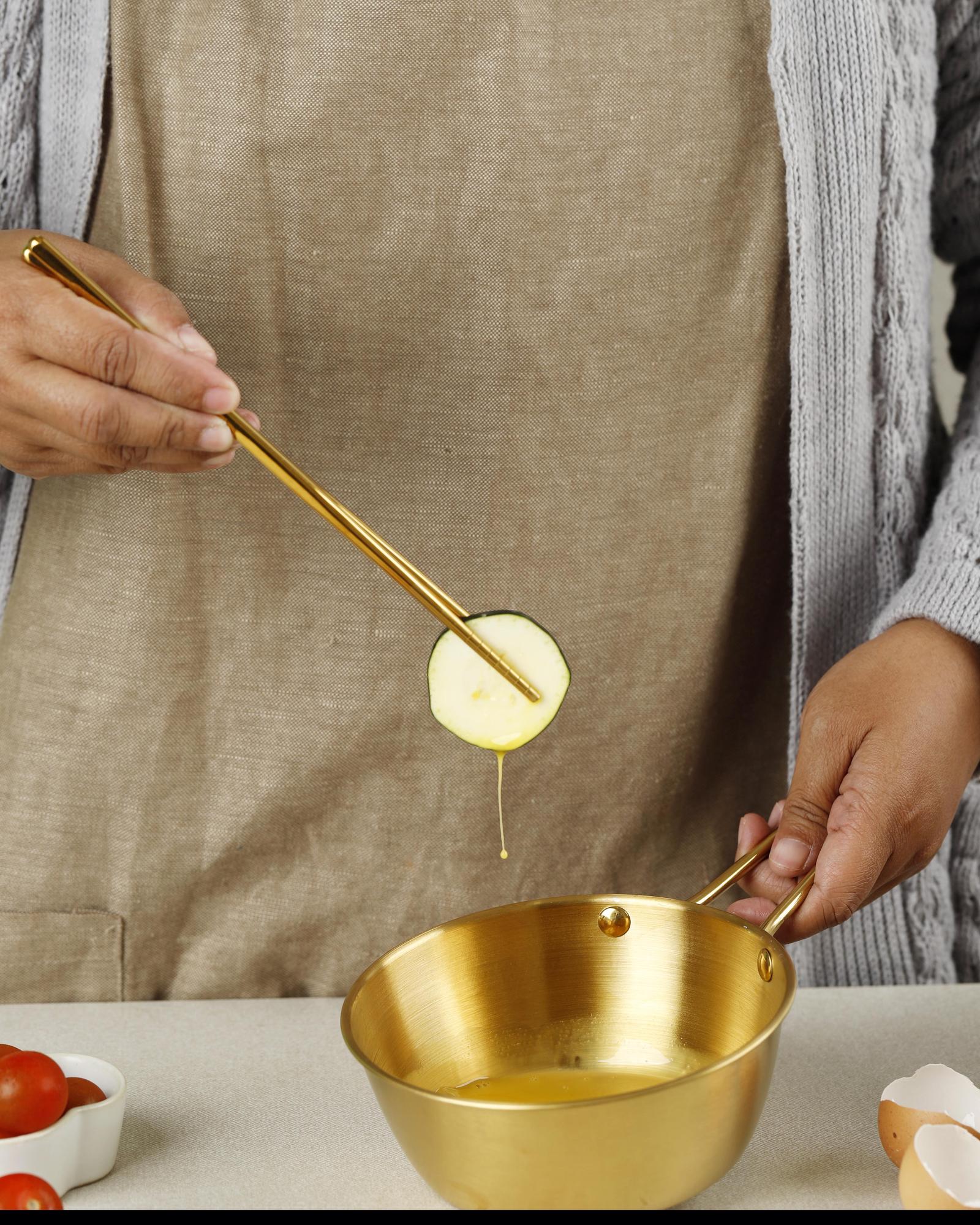 Hand whisking sauce in copper bowl